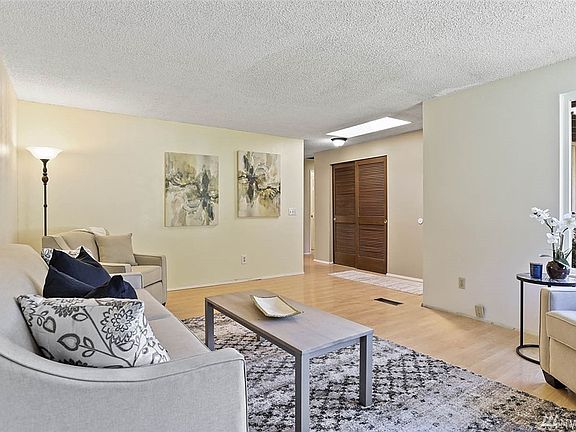 This view of the living room opens to the hallway towards the kitchen, showing a skylight in the entry.