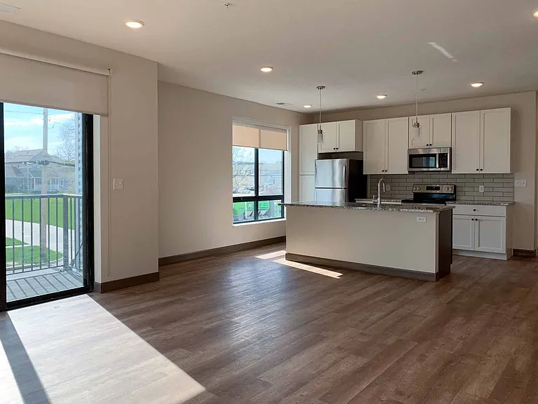 The open living room and kitchen of the two-bedroom Travertine in the light finish style