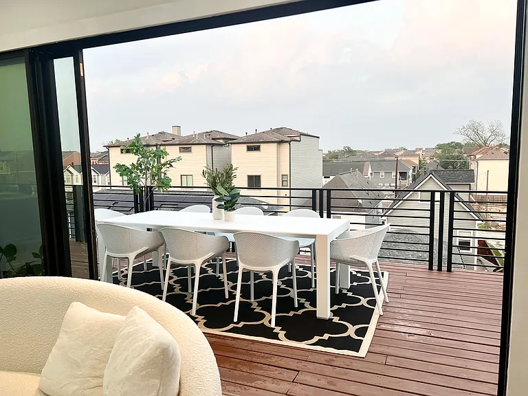 Expansive rooftop deck with retractable sliding glass doors to 4th floor living/media area