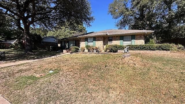Ranch-style home featuring a front yard