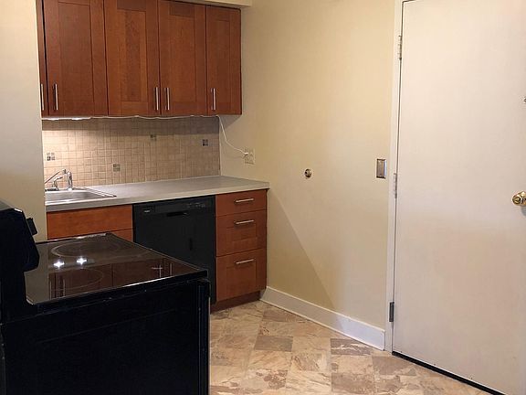 Kitchen showing front entry and cherry finish ceiling fan.