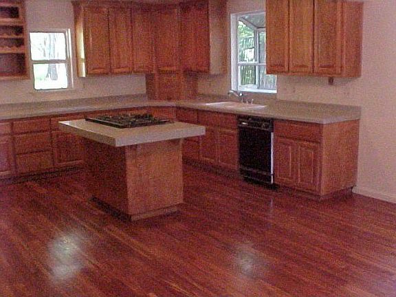 Enormoose kitchen with a downdraft cook island and wood floors.