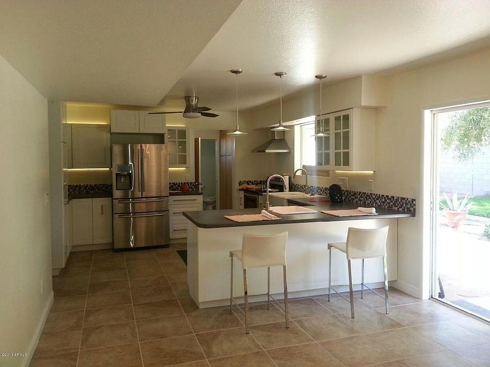 Remote-controlled Hunter light and fan in the kitchen. Counter sitting room for 4 children The entrance to the left of the refrigerator leads to the dining room. Door to to left of the stove leads to the storage closets hallway, half bathroom, backyard,
