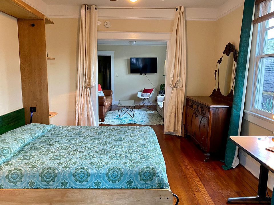 Front bedroom has Murphy bed which stows away easily to use space as office. French Doors separate bedroom from living room with privacy curtains.