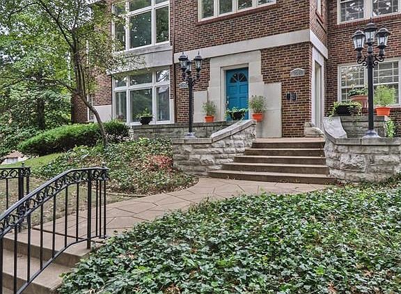 Charming curb appeal from street with brick/stone exterior, landscaping and large front terrace