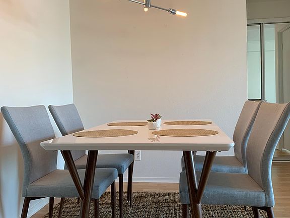 Large dinning area enough space for 6 chairs, hallway linen closet in the background.