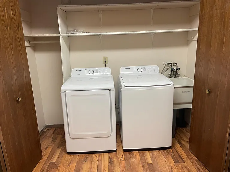 Spacious laundry room with newer appliances and wash sink.