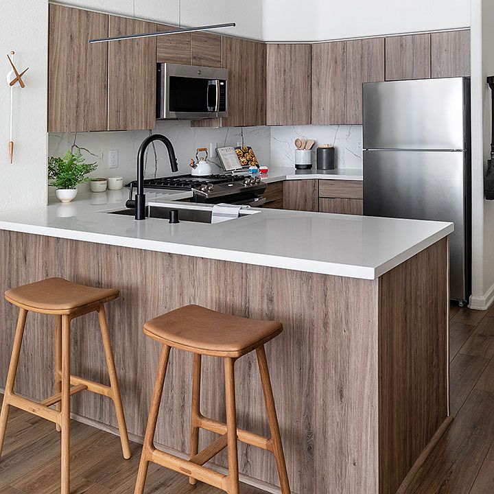 Apartment Kitchen with Stainless Steel Appliances, quartz counters and wood floors.