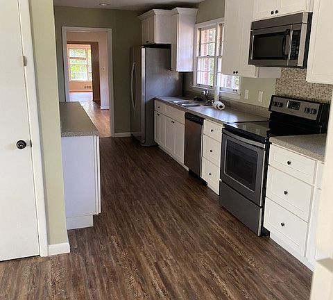Updated kitchen with stainless appliances including double-
sided refrigerator, glass top electric range, microwave, and dishwasher.