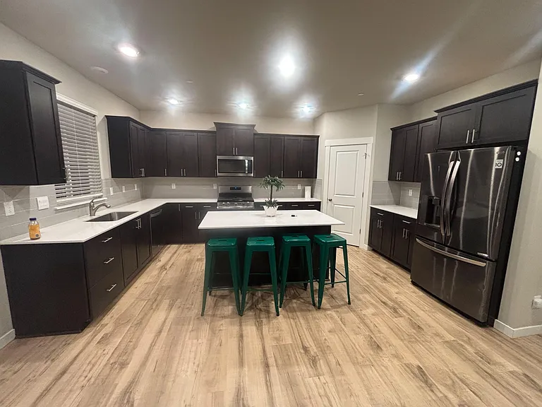 Large kitchen with an island breakfast bar, generous cabinet storage, and stainless-steel appliances for everyday cooking.