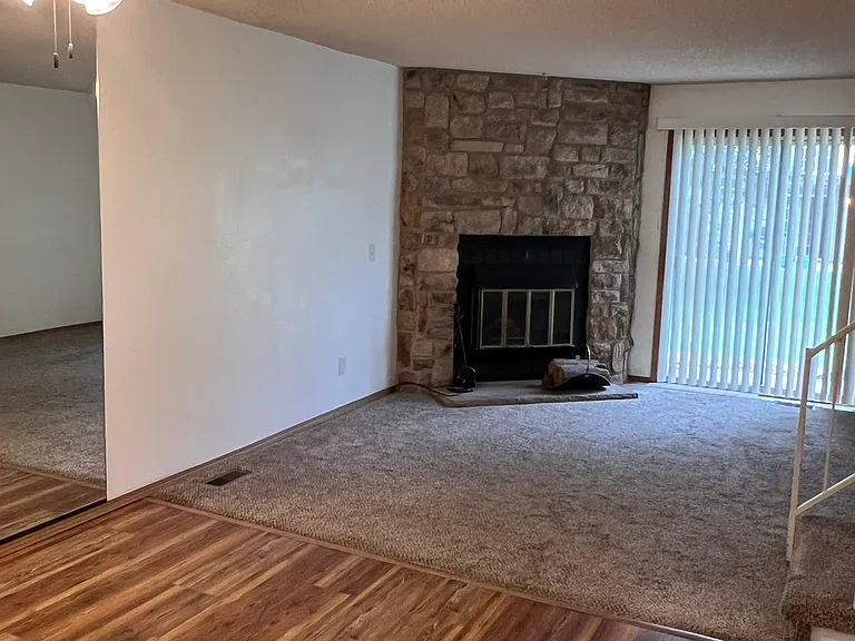 Dining area with newer LVP and living area with wood burning fireplace, serviced annually.