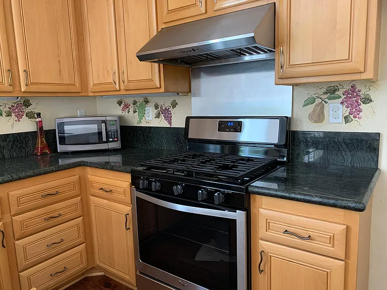 Kitchen with stainless steel brand new gas stove and dishwasher appliances.