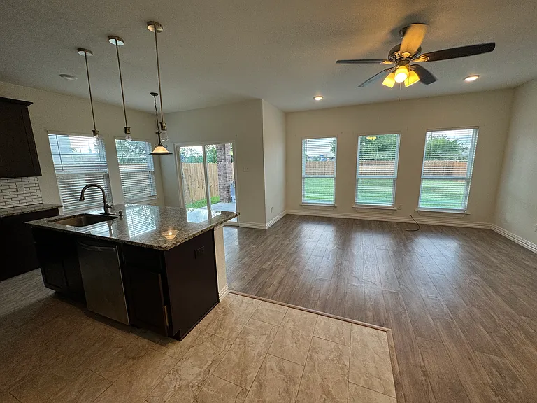 View of the kitchen, living area and backyard on the background