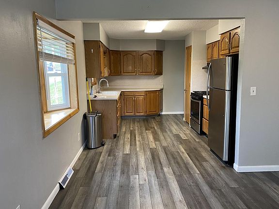 A quaint kitchen is fully stocked with an updated refrigerator, oven, and dish washer. 