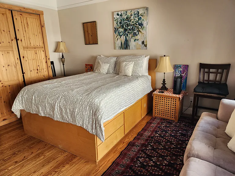 Large master bedroom with armoire and sofa