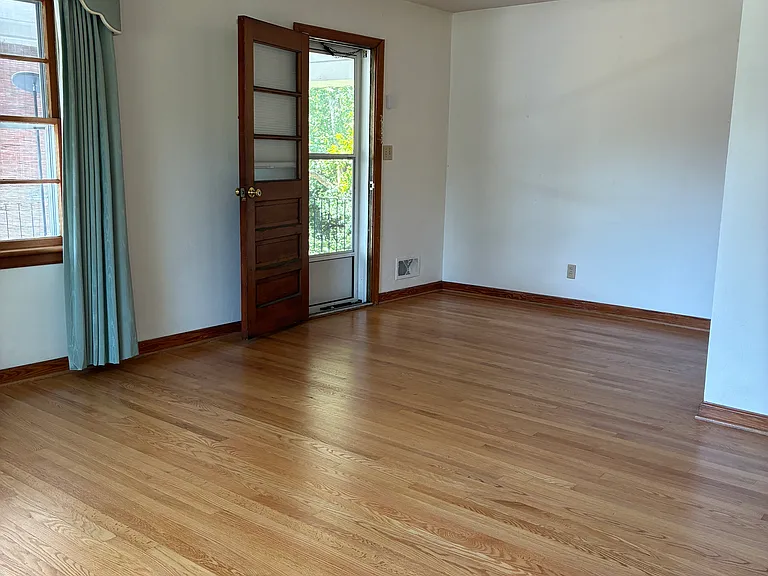 Large living room with easy access to the carport, kitchen, and front doors. Beautiful hardwood floors.