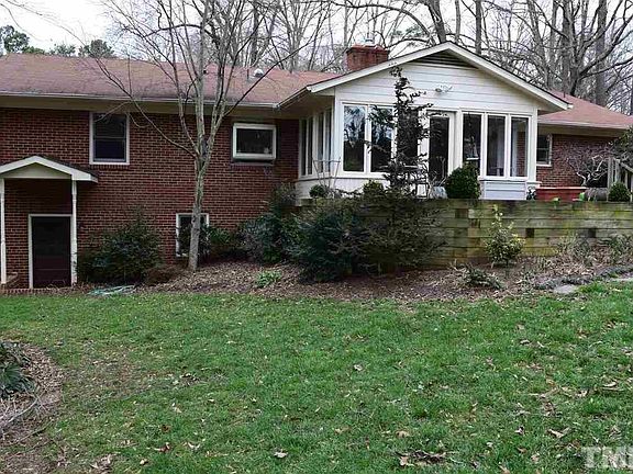 Rear of home that shows sun room and basement exterior door.