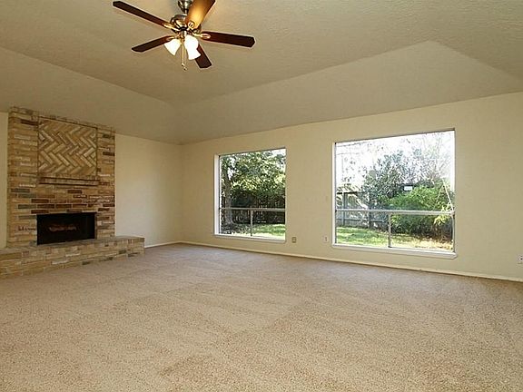Living Room features High Ceilings, Big Fireplace w/ Interesting Brickwork & Picture Windows with backyard view!