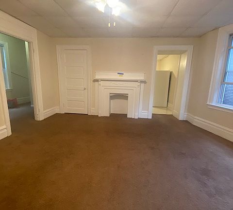 Large living room with decorative fireplace and large windows