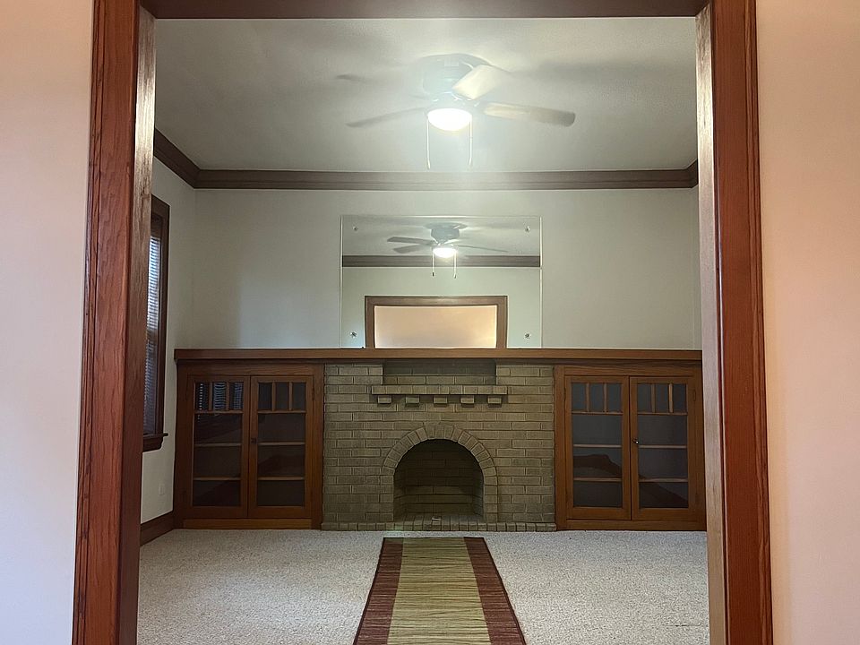 Decorative brick fireplace with built in bookshelves and solid oak mantle / Living Room