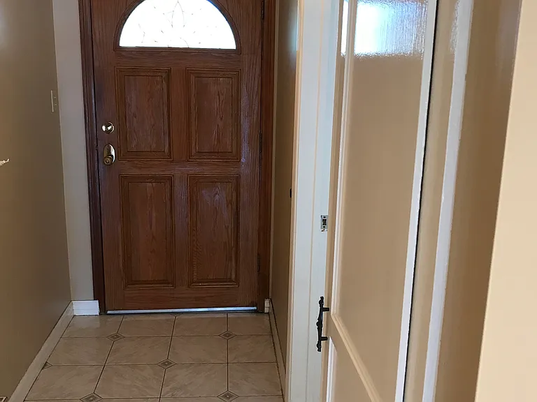 Front entryway with tiled floor and coat closet.