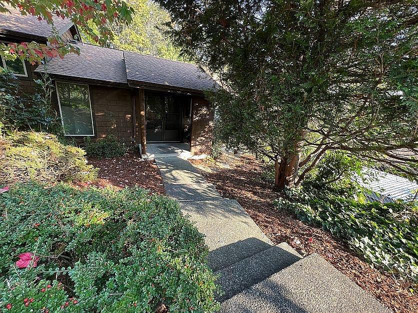 Front entrance and yard with established trees and greenery. Desirable end unit.
