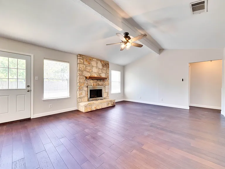 Spacious Living Room: Relax and unwind in the expansive living room complete with vaulted ceilings and a cozy fireplace, creating a warm and inviting atmosphere.