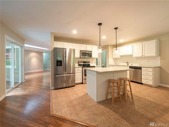 Updated kitchen with new appliances, inlaid ceramic tile flooring surrounded by bamboo flooring, new cabinets and gorgeous granite.