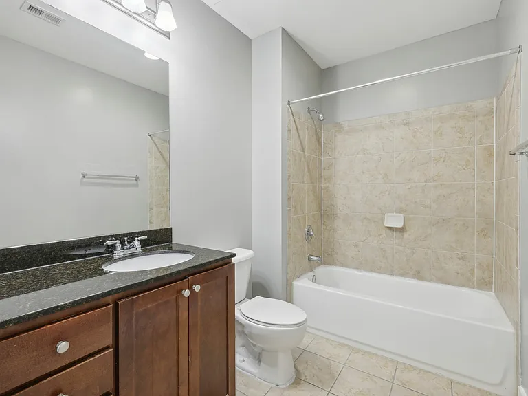Bathroom with granite vanity and tiled shower-tub combo