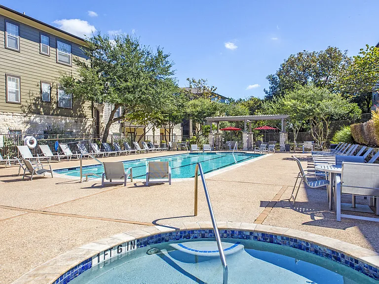 Resort Style Pool with water feature and poolside umbrella seating