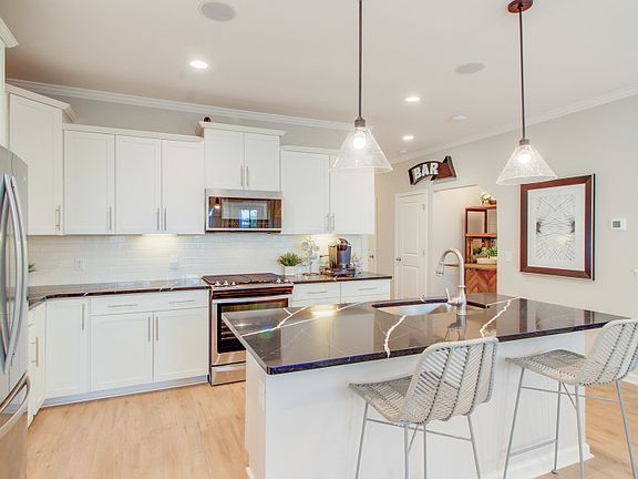 Open Kitchen with white cabinets and a spacious center island, perfect for meal prep - Model Repres
