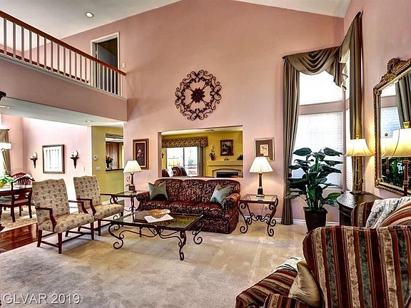 Standing in the entry foyer looking into the formal living room. The upstairs walkway leads to the separate master.