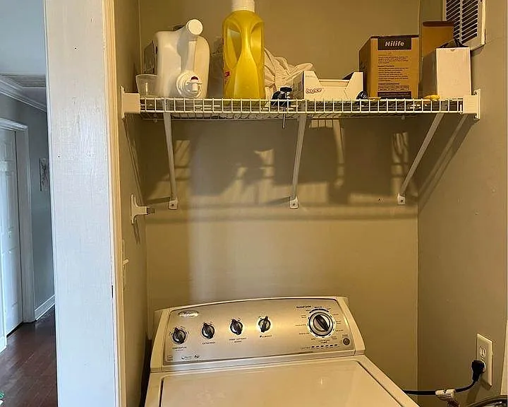 Laundry area with shelving for storage and supplies.