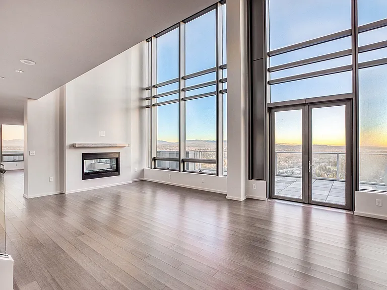 Open concept living room with floor to ceiling windows overlooking the city