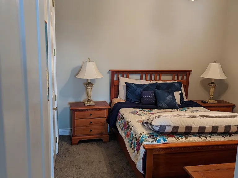 Bedroom #2. Positioned on the opposite end of the home from the Master Suite and adjacent the living room, the layout provides for privacy. This is a standard sized bedroom, unlike the massive Master Suite. It contains a queen size bed, two night stands,