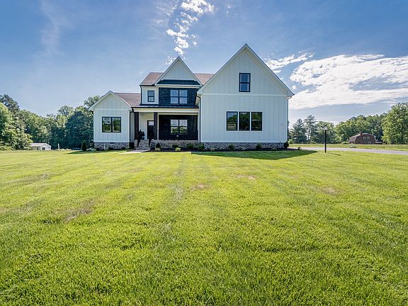 Modern farmhouse Hanover apartment with white siding, black accents, and large windows under a sunny