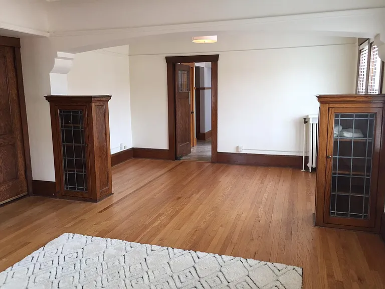Living Room looking toward dining room and kitchen entrance. Beautiful hardwood floors and built-in cabinets - great for storage!