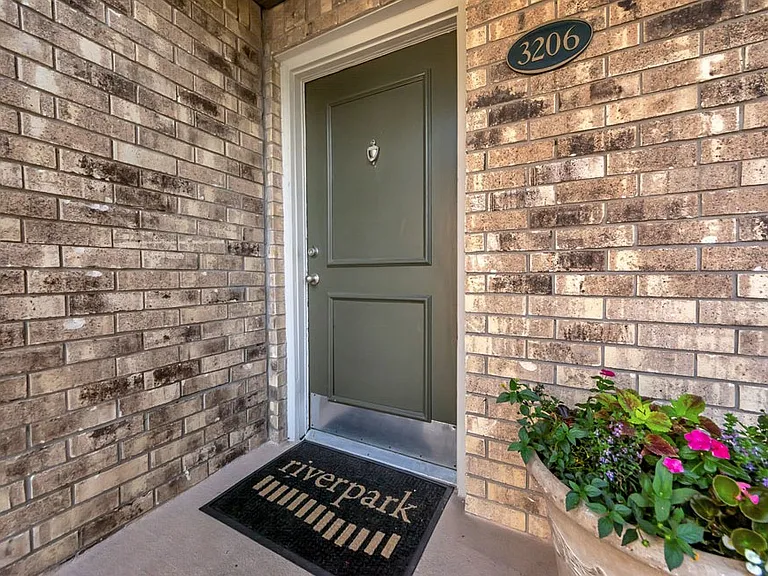 Private apartment entry with welcoming front door and brick exterior