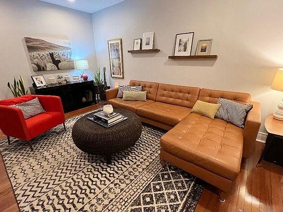 Living room w/ recessed smart lighting and hardwood floors.