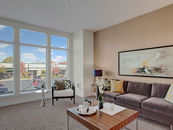 Living area with floor to ceiling windows overlooking nearby landscaping