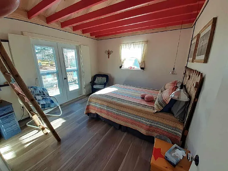 Master bedroom has queen sized bed and french door to access deck.