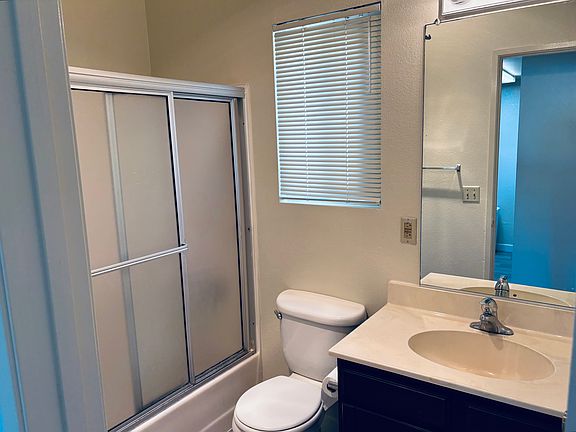 Bathroom with tub, shower, and under-sink storage.