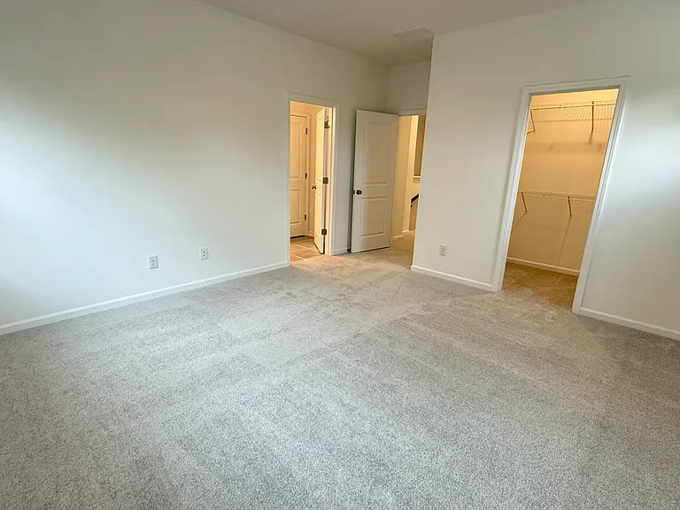 Spacious primary bedroom with abundant natural light and walk-in closet.