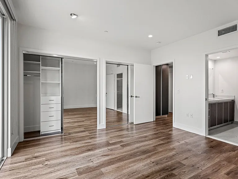 Bedroom with Two Closets with Built-In Organizers, Balcony, and Bathroom