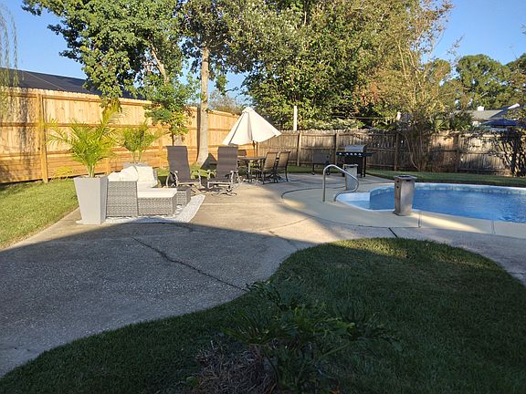 pool area offers grill and cooler chest with lots of seating and lounging areas.