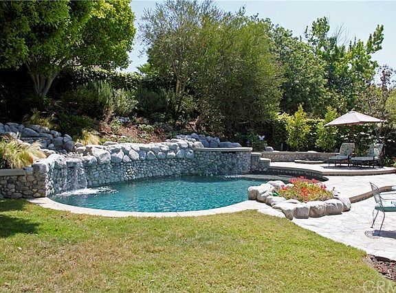 WOW! Soothing fountains trickle into the sparkling pool! Spa, fire pit, built-in bbq and covered pat