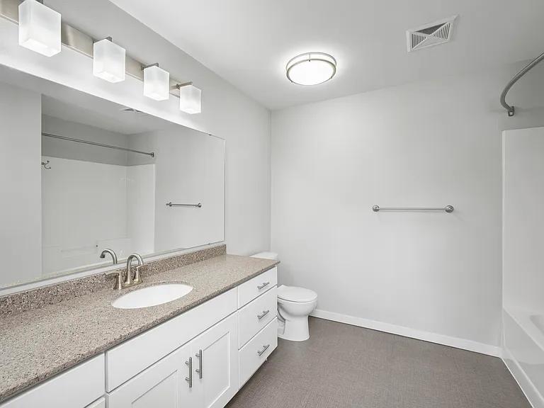 Contemporary bathroom featuring elegant lighting, a granite countertop, and modern fixtures for an inviting atmosphere. Contemporary bathroom featuring elegant lighting, a granite countertop, and modern fixtures for an inviting atmosphere.