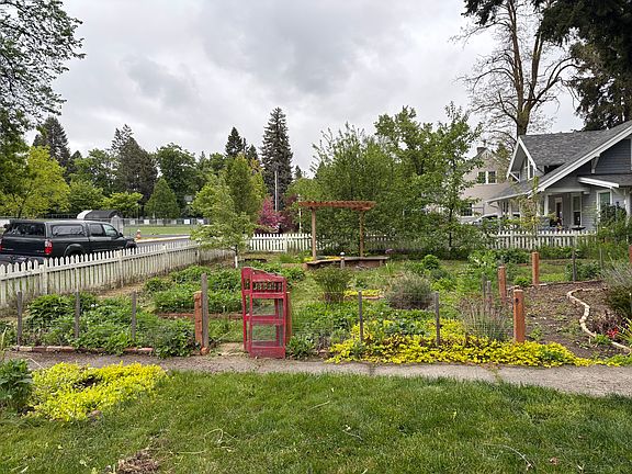 Fenced garden area with fruit trees and flowers.
