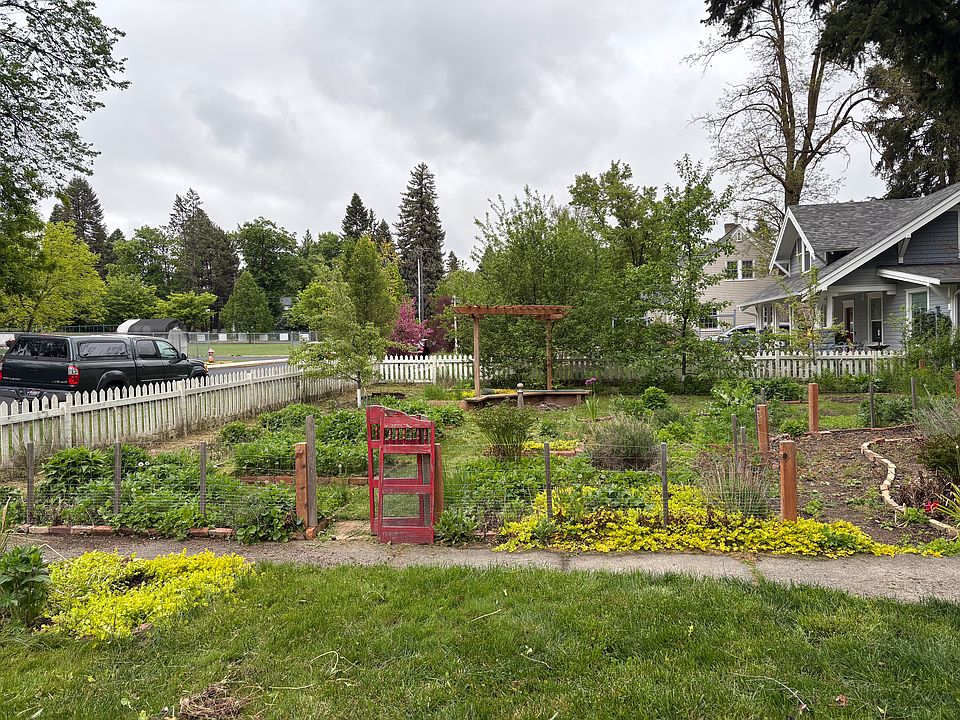 Fenced garden area with fruit trees and flowers.