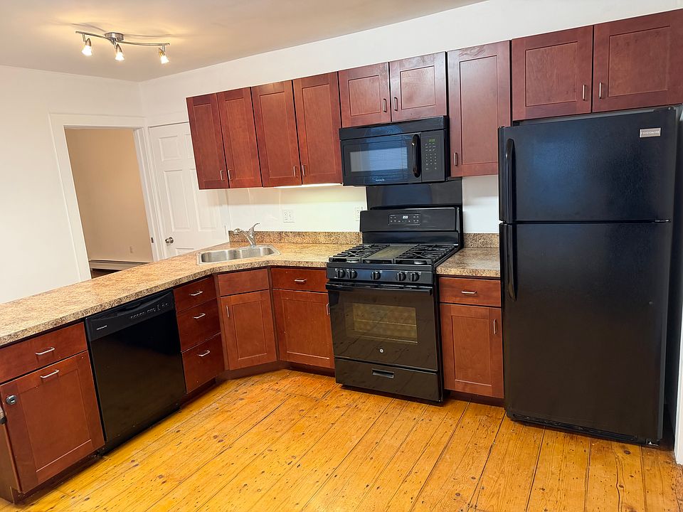 View of Kitchen Appliances and Cabinets. Gas Range, Microwave, Fridge and Dishwasher